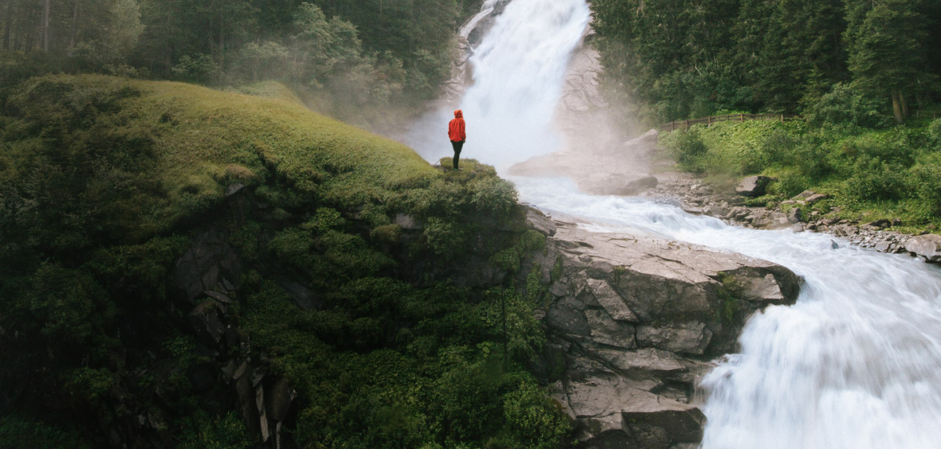 Mensch in den Bergen mit Wasserfall